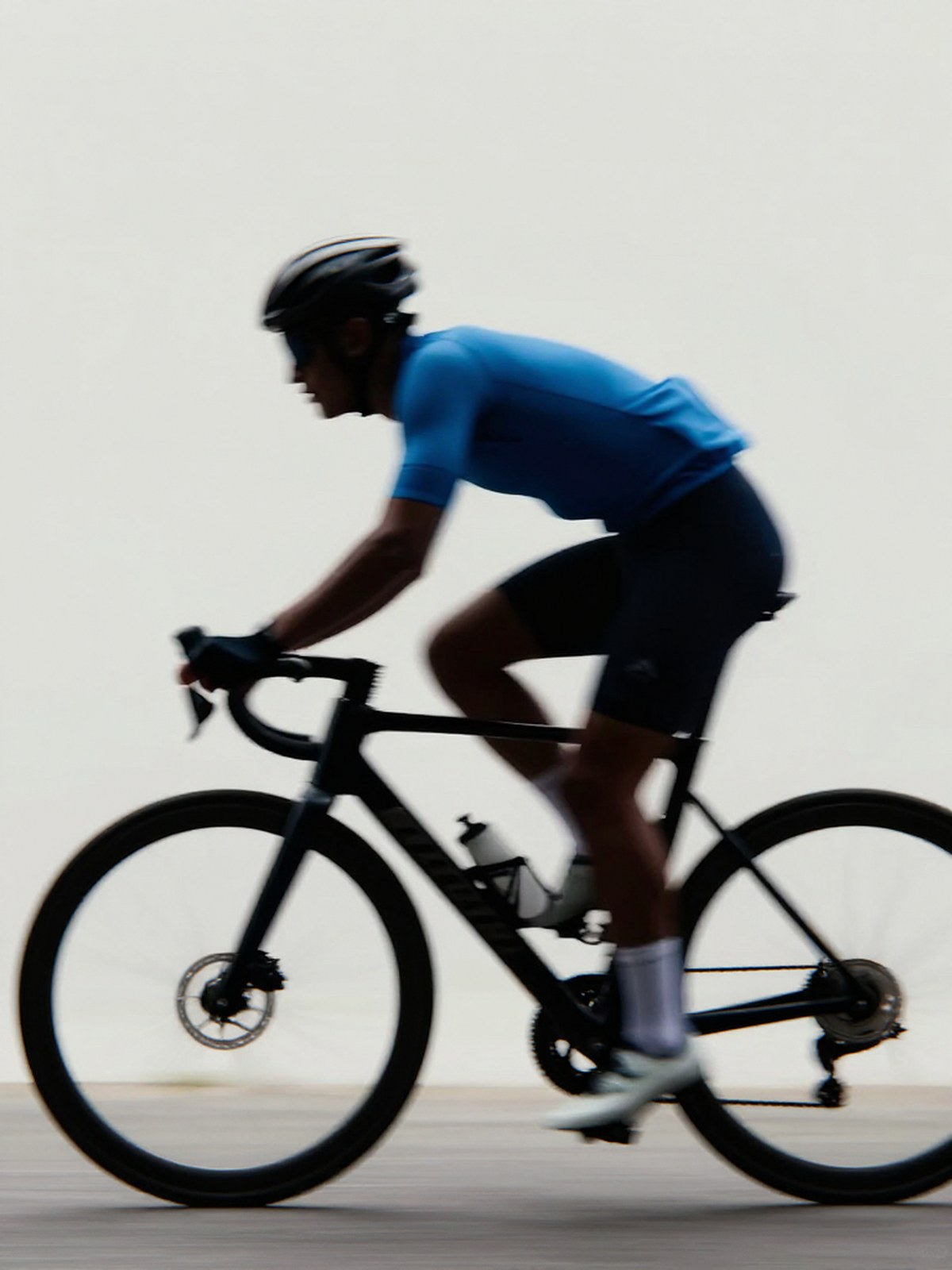 Z-Image Turbo generation: A blurred silhouette of a cyclist in motion, wearing a blue sports kit, captured with a sl…