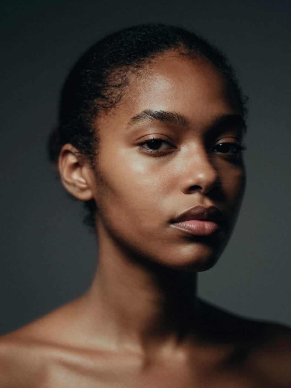 Z-Image Turbo generation: Ultra-close editorial portrait of a young Black woman in a dark studio, hair pulled into a…
